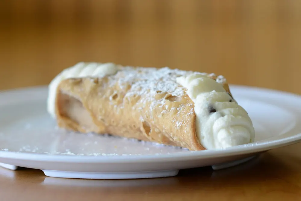 A cannoli dusted with powdered sugar