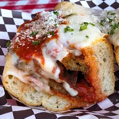 A parm hero with marinara and melted mozzarella on a hero roll