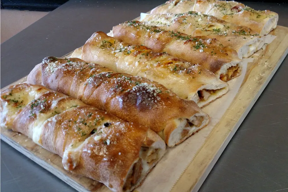 A baked stromboli filled with ham, salami and pepperoni