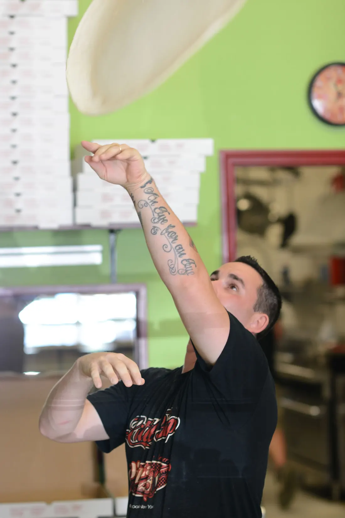 Hand-tossing fresh pizza dough in the shop